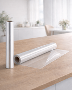 Transparente FolioContact Wandschutzfolie als Rolle auf einem Holztisch in heller Küche